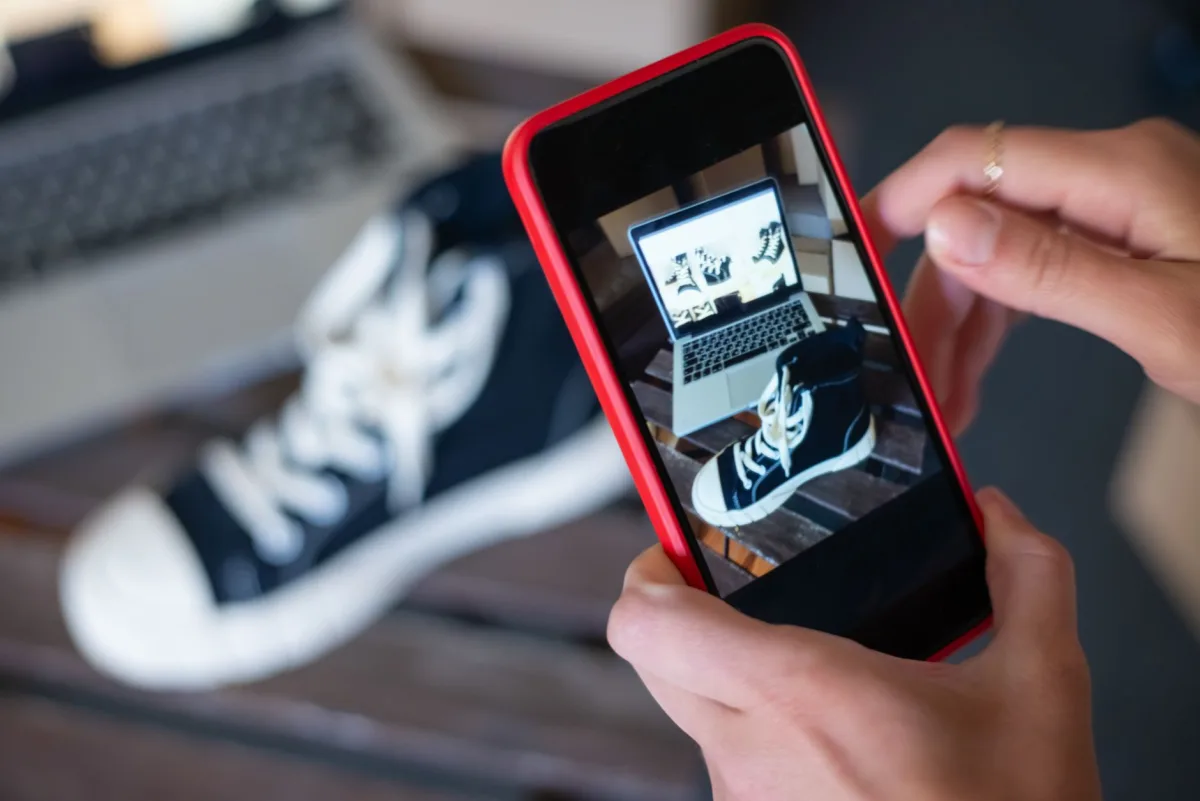 A smartphone displaying a high‑resolution product photo of sneakers, illustrating mobile‑first e‑commerce.