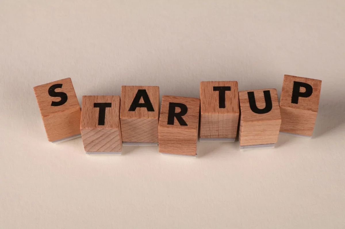Wooden blocks forming the word 'STARTUP' on a neutral background