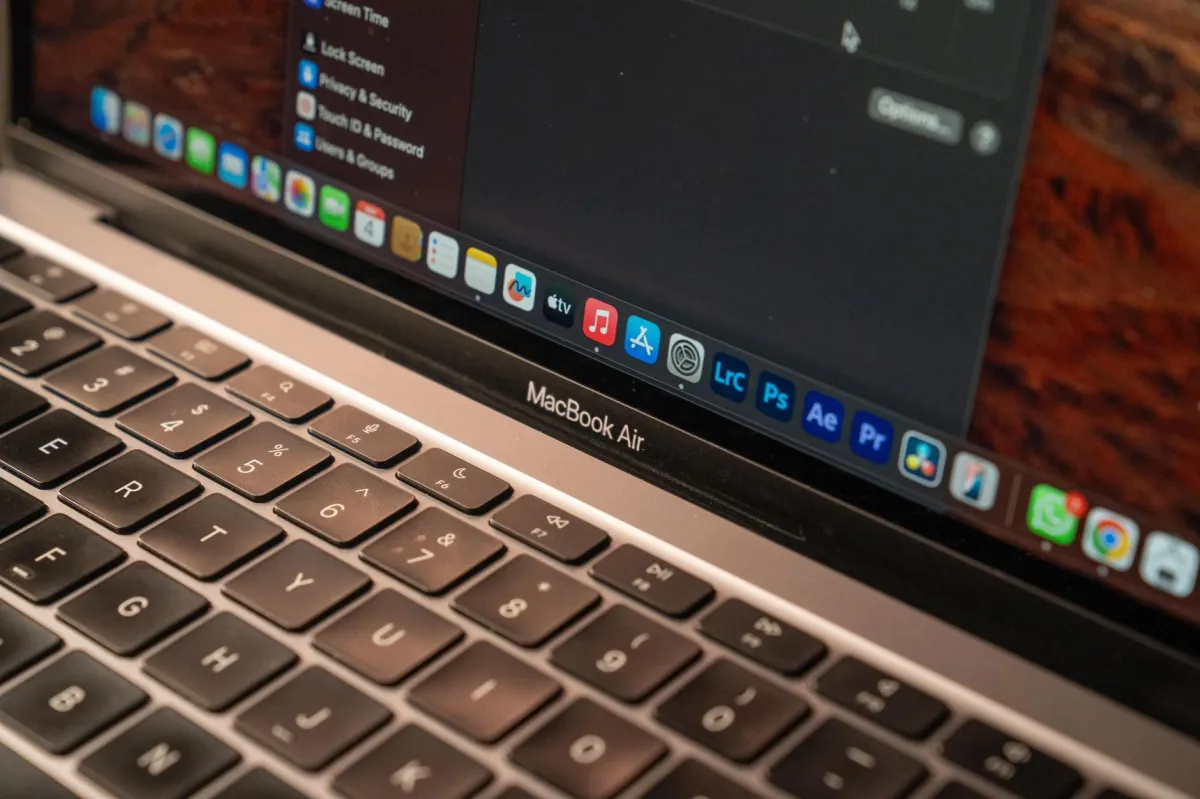 A detailed view of a MacBook Air with a focus on the keyboard and screen displaying app icons.