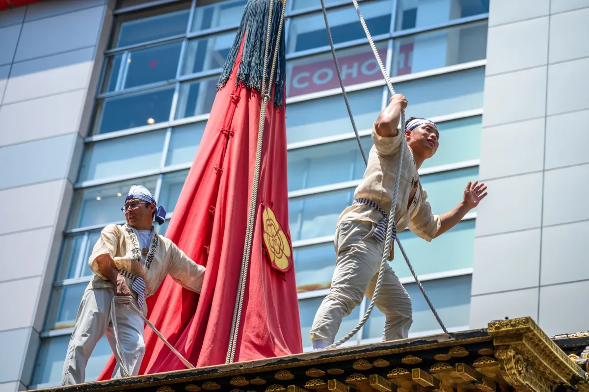 Performers in traditional attire participate in a lively Japanese festival outdoors.