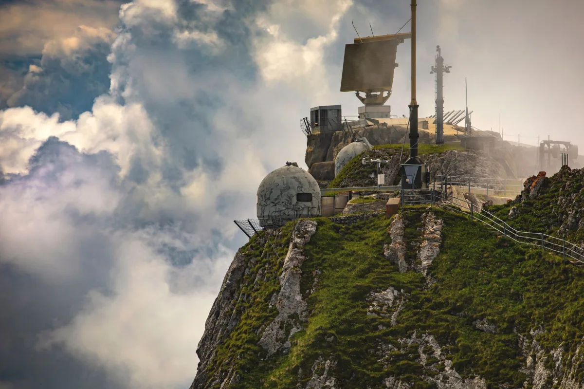 Mountain observatory equipped with radar, illustrating remote sensing of atmospheric phenomena.