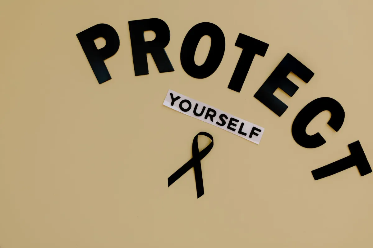 Black ribbon on yellow background with text advocating self-protection and awareness.